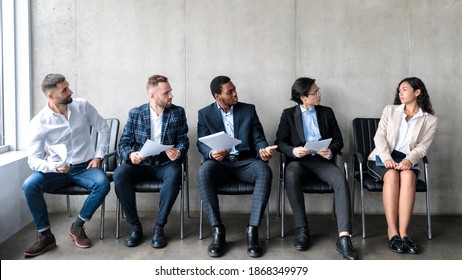 Employment Discrimination. Diverse Businessmen Staring At Lady Applicant Waiting For Job Interview Sitting On Chairs Indoor. Female Gender Prejudice At Work, Sexism And Career Inequality. Panorama