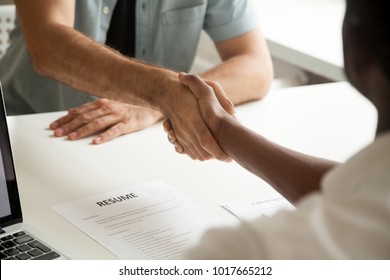 Employment handshake or making good first impression at successful interview concept, african employer and caucasian employee shake hands, black recruiter welcoming new white job candidate, close up - Shutterstock ID 1017665212