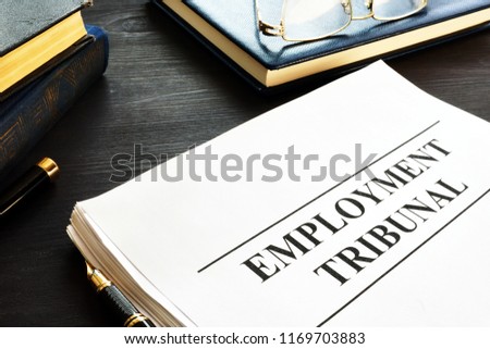 Employment tribunal documents, note pad and glasses.