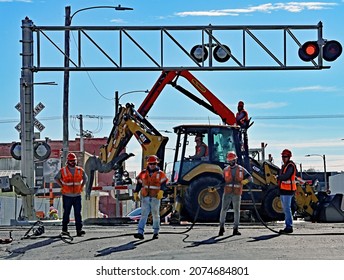 Emporia, Kansas, November 14, 2021 Railroad Track Maintenance Workers From (BNSF) Work On Replacing Worn Track Ties At The Main Crossing On Commercial Street While Freight Trains Continue To Pass By 