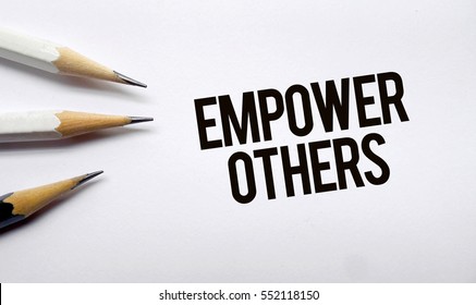 Empower Others Memo Written On A White Background With Pencils