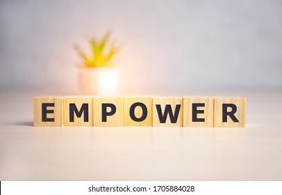 Empower word written on wood block, text concept
