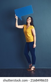 Empower Your Voice. Studio Portrait Of An Attractive Young Woman Holding A Speech Bubble Against A Blue Background.