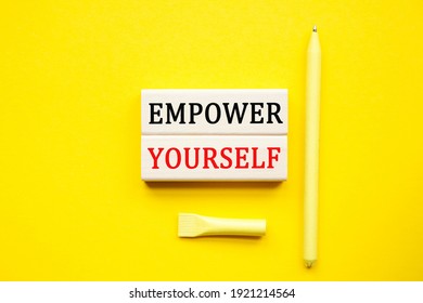 EMPOWER YOURSELF text on the cubes. yellow pen on a yellow background. a bright solution for business, financial, marketing concept. Copy space