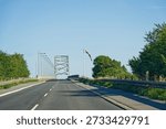 Empty access road rises toward Dronning Alexandrines Bro, guiding traffic onto the bridge and symbolizing movement, connection and Scandinavian infrastructure
