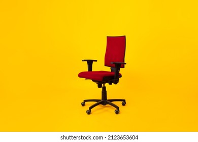 Empty Adjustable Ergonomic Office Chair With Armrests Over Yellow Studio Background. Comfortable Furniture For Workplace Concept. No People, Full Length