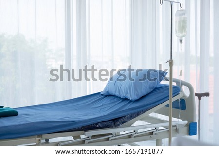 Empty adjustable patient 's bed in hospital room. Clean adjustable bed is for patient who admitted to hospital for medical treatment and rehabilitation. Hospital health care insurance & P.A. concept. 