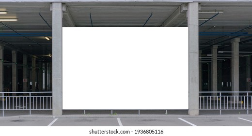 Empty Advertisement Banner Of White Colour Located Between Grey Concrete Building Beams At Parking Lot On Summer Day