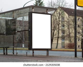 Empty Advertisement Display At A Bus Shelter In A City. Blank Billboard Mockup For Marketing In The Public Sphere. Template For Testing The Design Of An Ad Next To A Street.