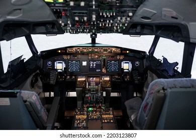 Empty Airplane Cockpit Used By Captain And Copilot To Fly, International Airways Jet With Control Panel Buttons, Steering Wheel And Dashboard Command. Flying Plane With Engine Throttle.