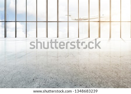 Empty airport hall with window of glass and flying airplane over blue sky background