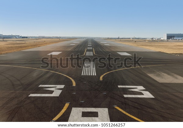 empty
airport runway with white markings for
aircraft