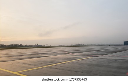 
Empty Airport Runway With Yellow Markings For Aircraft After Rain