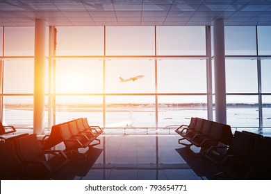 Empty airport terminal lounge with airplane on background. Sunset colors - Shutterstock ID 793654771