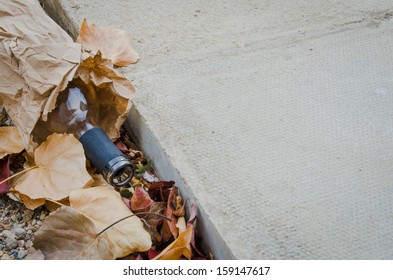 An Empty Alcohol Bottle Laying At The Curb With An Large Area Of Concrete Sidewalk For Your Text Message.