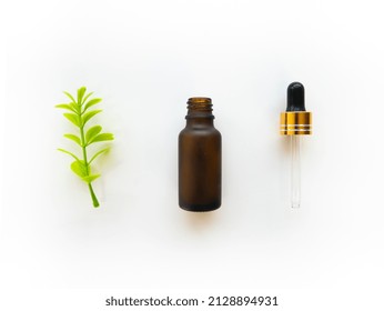 Empty Amber Bottle For Beauty Skincare With Dropper And Fresh Green Leaf Isolated On White Background