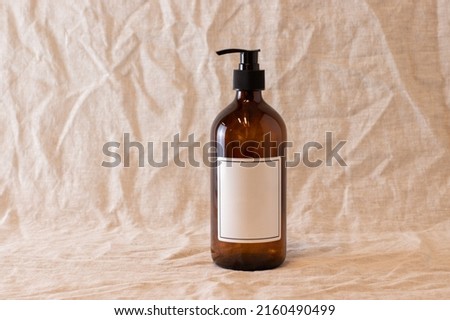 Empty amber glass soap or shampoo bottle on isolated background. Skin care or hair concept with natural cosmetics.