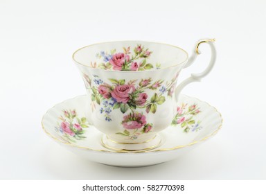 Empty antique cup and saucer with rose decoration isolated on white - English tea