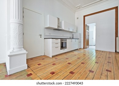 Empty apartment with modern kitchen and designed hardwood floor after renovation