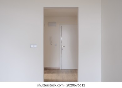 An Empty Apartment With White Interior Walls And A Phone Handing On The Wal Daytime