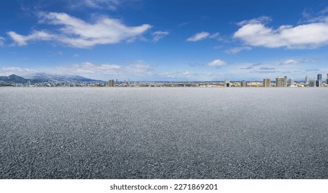 Empty asphalt floor with faraway cityscape background - Shutterstock ID 2271869201