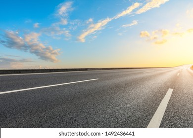 Empty Asphalt Highway And Beautiful Sky Clouds At Sunset