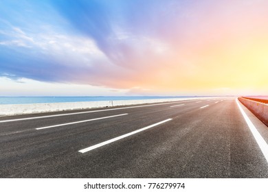 Empty Asphalt Highway And Blue Sea Nature Landscape At Sunset