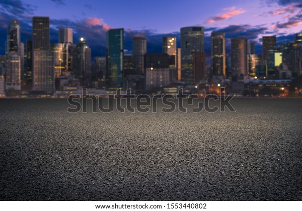Empty asphalt highway and\
building with nice sky clouds. Asphalt road at sunset with city\
background. 
