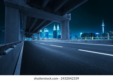 Empty asphalt highway road under overpass and city view. Night scene. - Powered by Shutterstock