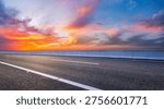 Empty asphalt highway under a dramatic and colorful sunset sky with vibrant clouds 