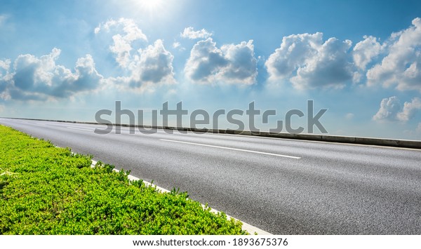 Empty asphalt road and blue sky with white\
clouds.Road background.