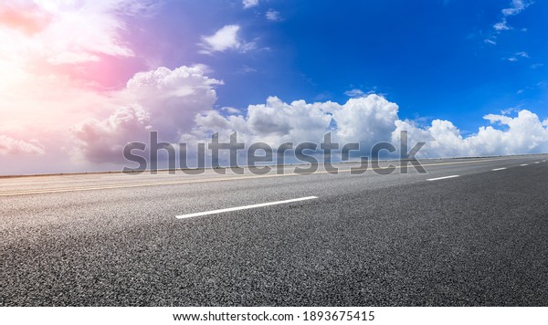 Empty asphalt road and blue sky with white\
clouds.Road background.