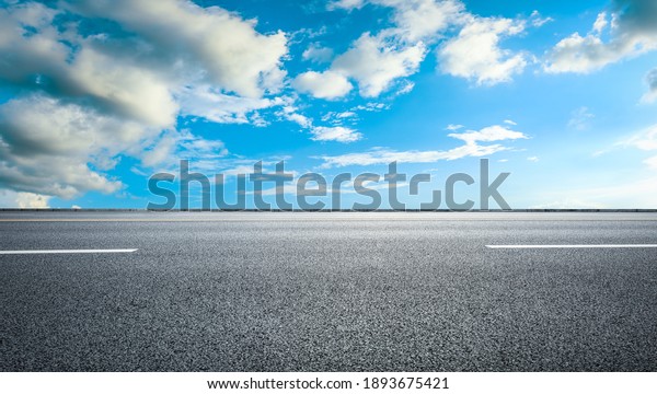 Perspective empty asphalt road and blue sky with white clouds. Road background mural.