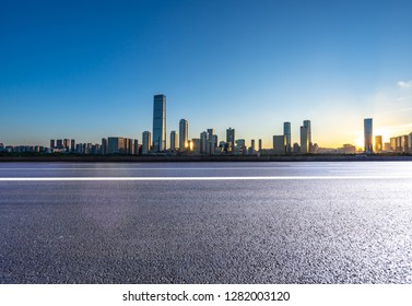 empty asphalt road with city skyline - Shutterstock ID 1282003120