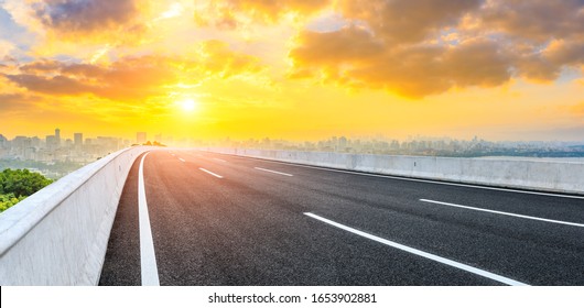 Empty asphalt road and city skyline at sunrise in Hangzhou,China.