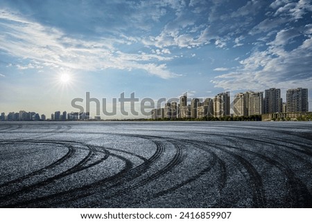 Empty asphalt road and city skyline background