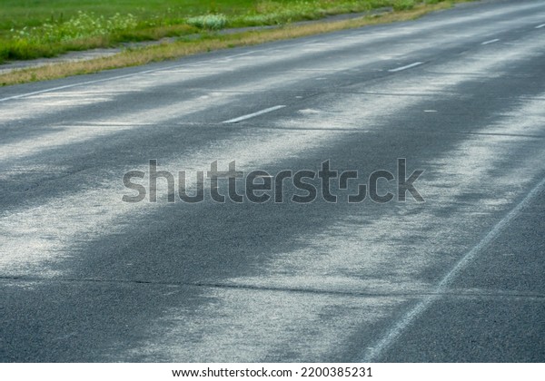 Empty\
asphalt road close-up against the sky. Empty background, space for\
text. New asphalt concrete pavement in rural\
areas.