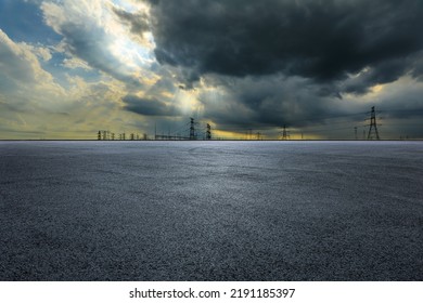Empty asphalt road ground and high voltage power towers on cloudy day - Shutterstock ID 2191185397