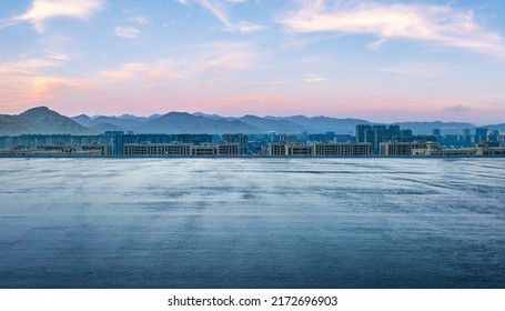 Empty Asphalt Road And Modern City Skyline With Mountain Scenery At Sunset. High Angle View.