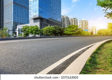 empty asphalt road and modern commercial buildings - Shutterstock ID 1075163003