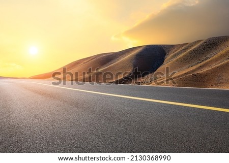 Empty asphalt road and mountain natural landscape at sunset