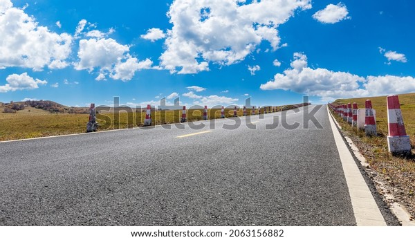 Empty asphalt road and mountain nature landscape\
under blue sky.