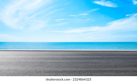 
Empty asphalt road near beach under blue sky