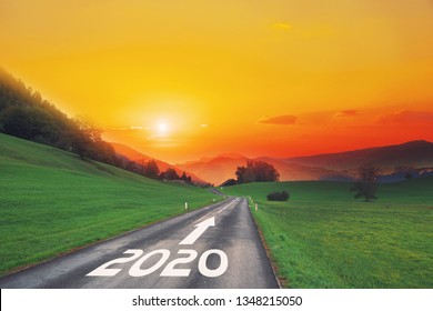 Empty asphalt road and New year 2020 concept. Driving on an empty road on goals in the mountains to upcoming 2020 and leaving behind old years. Concept for growth success, passing time and future.