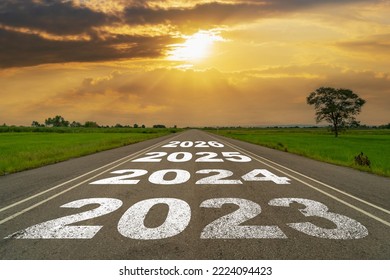 Empty asphalt road and New year 2023 concept. Driving on an empty road to 2023 with sunset.