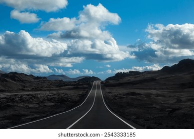 An empty asphalt road stretches through the barren volcanic landscape of Timanfaya National Park in Lanzarote, Canary Islands, Spain. - Powered by Shutterstock