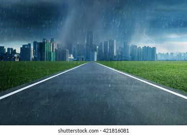 Empty asphalt road towards a city in storm - Shutterstock ID 421816081