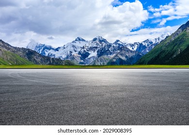 Empty Asphalt Road And White Snow Mountain Natural Scenery.