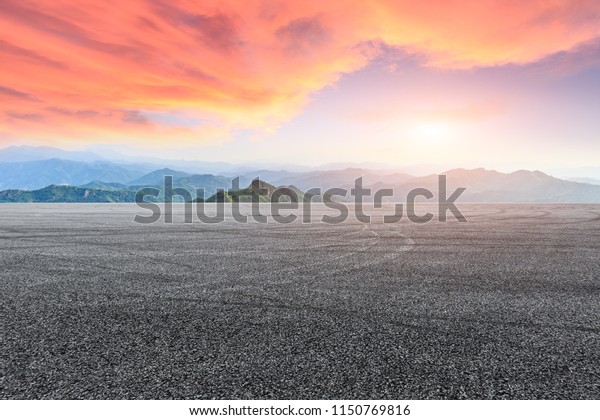 Empty asphalt square car tire brakes and mountain
scenery at sunrise