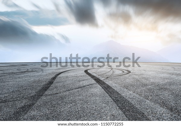Empty asphalt square car tire brakes and mountain\
scenery 